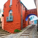 A cobbled street passing through an archway of a brightly coloured building in Portmeirion Village