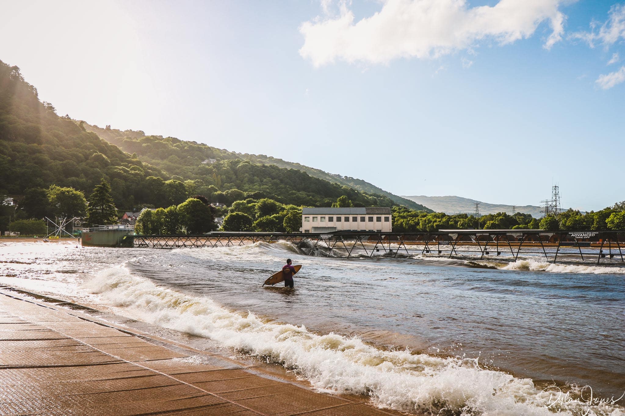 A surfer stands in the surf lagoon at Adventure Parc Snowdonia, one of the more popular North Wales activities