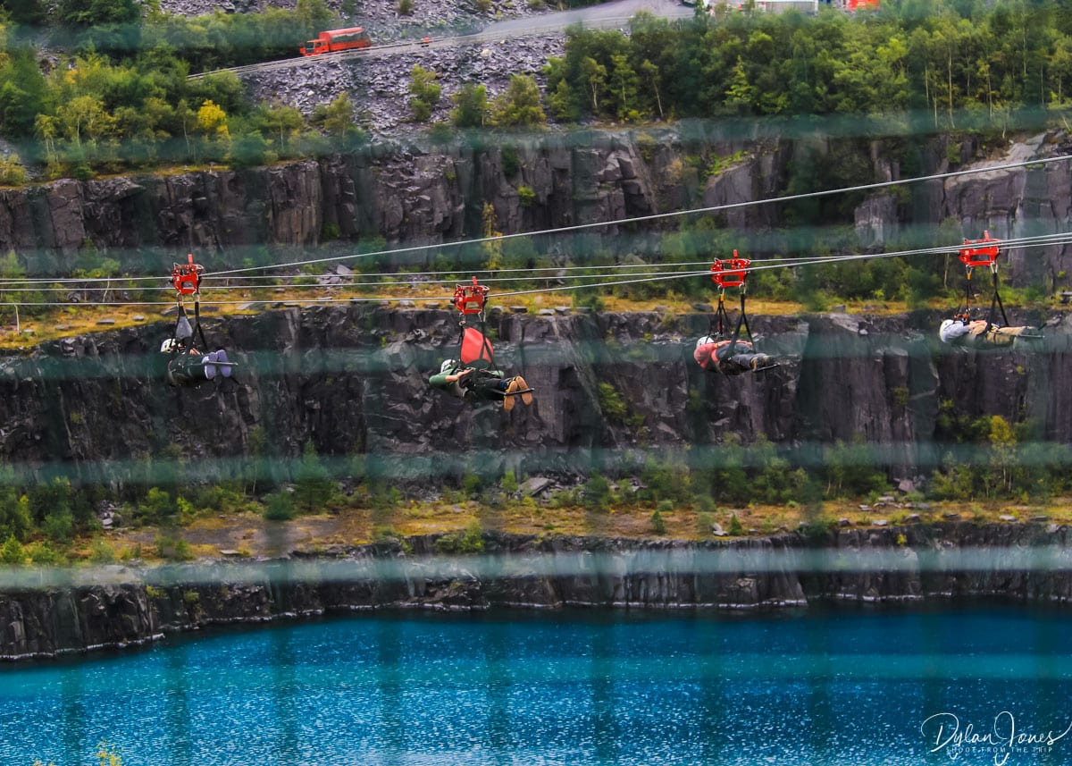 People riding the Velocity zip wire in Penrhyn Quarry